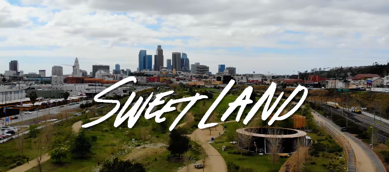 Sweet Land hand-lettering over set design at LA State Historic Park with Downtown Los Angeles skyline in the distance